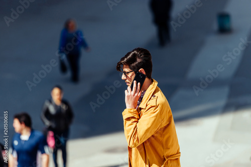 Urban businessman talking on mobile in city rush