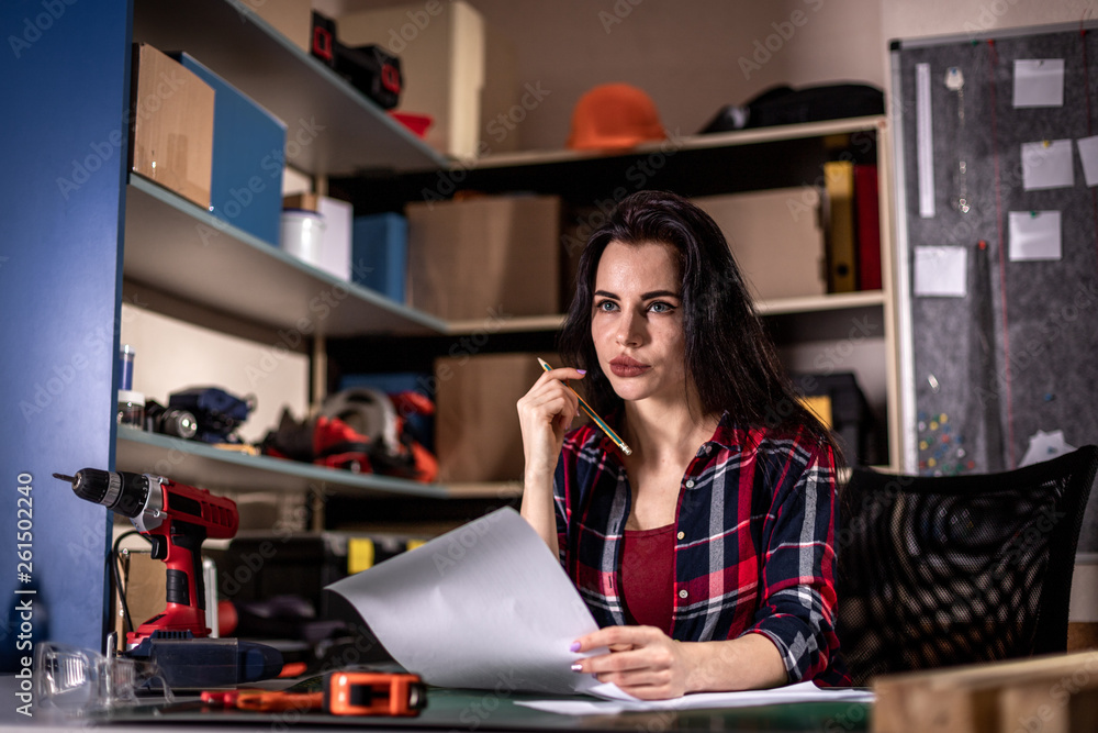 Craftsmen woman thinking an idea. Self employed female carpenter planning DIY project in her small business woodwork workshop Craftsmen woman thinking an idea. Self employed female carpenter planning DIY project in her small business woodwork workshop