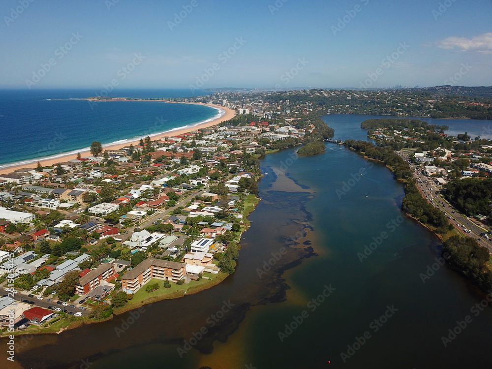 Aerial view of Narrabeen Lake, Narrabeen Beach, Collaroy Beach and Long Reef Head. Sydney CBD in the background.