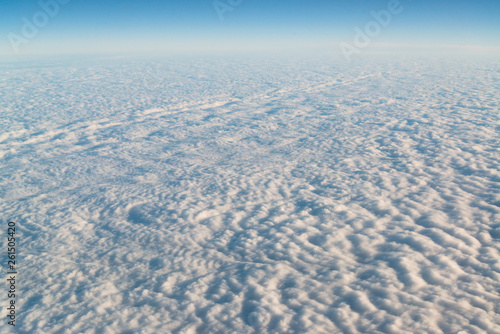 View from airplane on white thick clouds sky