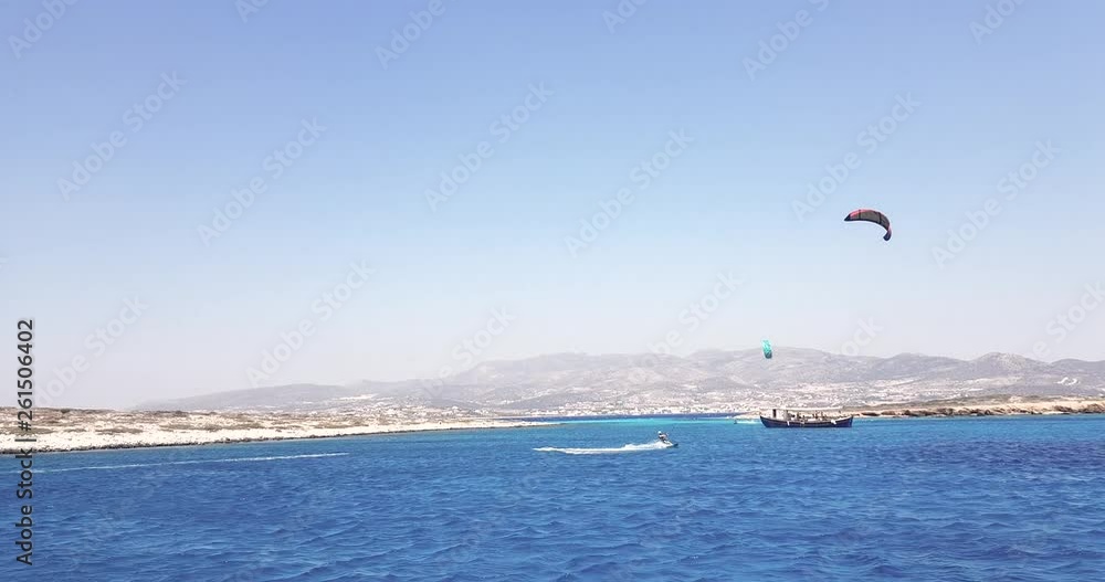 Extreme Kite Surfer rising into air on beautiful day in Antiparos, Greece Extreme Kite Surfer rising into air on beautiful day in Antiparos, Greece