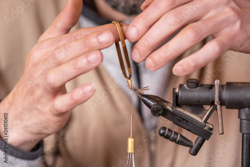 Close up of fisherman tying a fly for fishing .