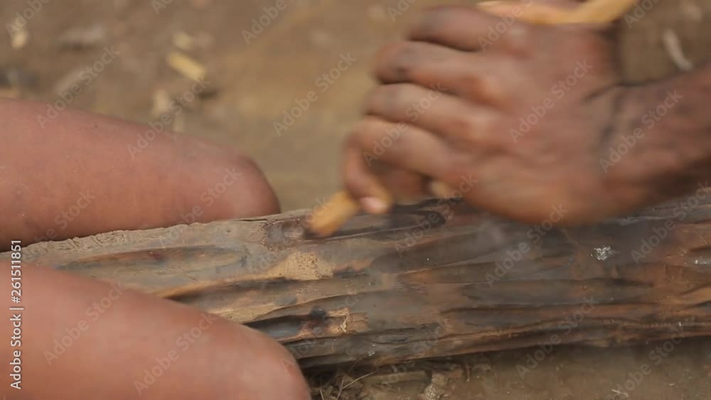 Closeup view of adult and child aboriginal`s hands that using a traditional hand-stick to get a fire. The tribal historic tradition of receiving the flame from the wood. Tanna Island in Vanuatu. Closeup view of adult and child aboriginal`s hands that using a traditional hand-stick to get a fire. The tribal historic tradition of receiving the flame from the wood. Tanna Island in Vanuatu.