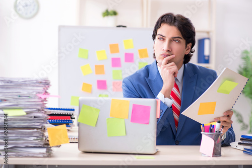 Young male handsome employee in conflicting priorities concept 