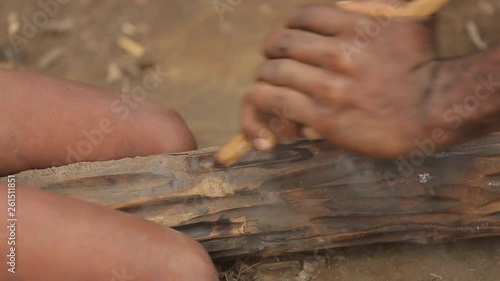 Closeup view of adult and child aboriginal`s hands that using a traditional hand-stick to get a fire. The tribal historic tradition of receiving the flame from the wood. Tanna Island in Vanuatu. photo