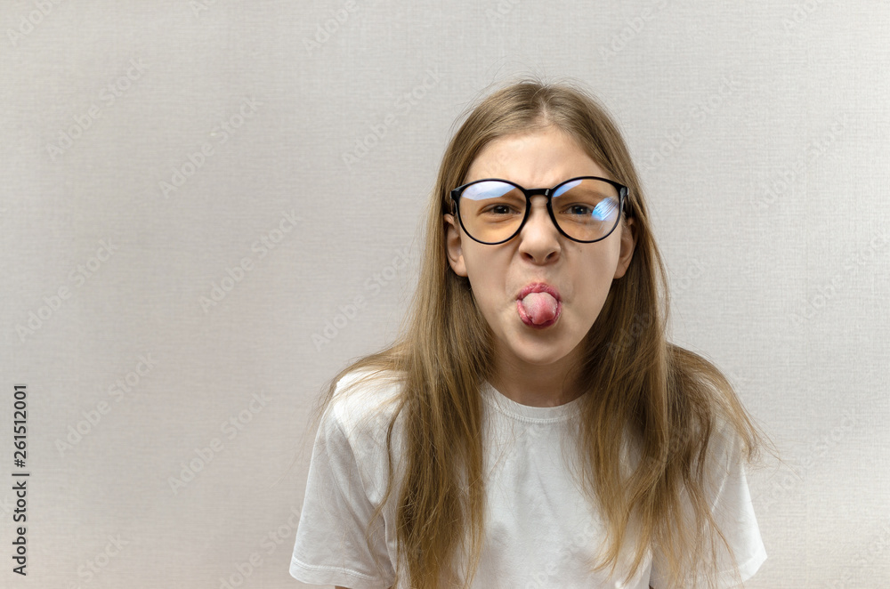 Funny blonde girl in glasses writhing her face, mimicking, having fun. Close-up. Funny blonde girl in glasses writhing her face, mimicking, having fun. Close-up.