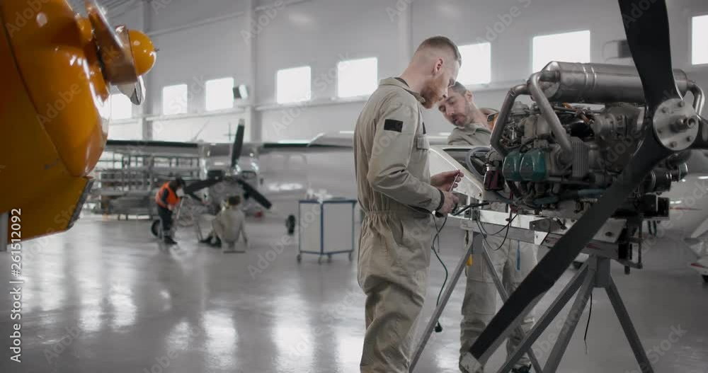 Two aviation engineers examining engine of aircraft Stock Video | Adobe ...