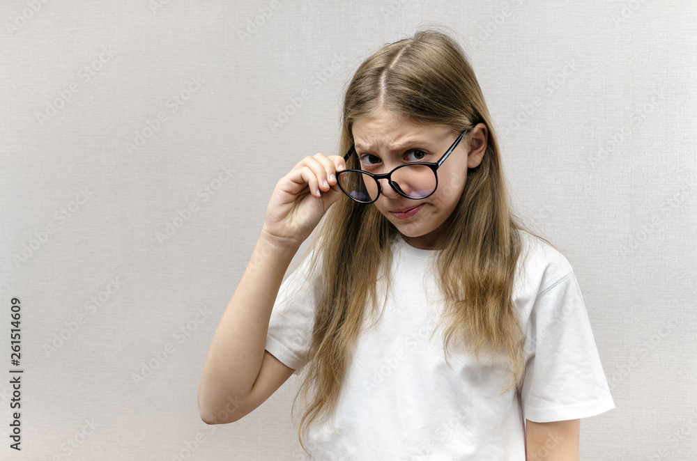 Cute girl with glasses look with a suspicious look. Doubt, mistrust, surprise Cute girl with glasses look with a suspicious look. Doubt, mistrust, surprise