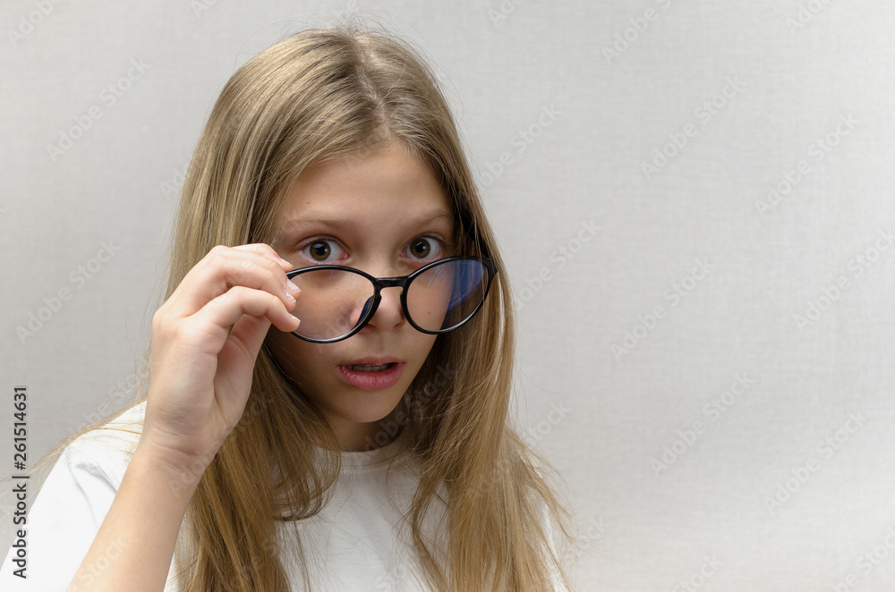 Cute girl with glasses look with a suspicious look. Doubt, mistrust, surprise Cute girl with glasses look with a suspicious look. Doubt, mistrust, surprise