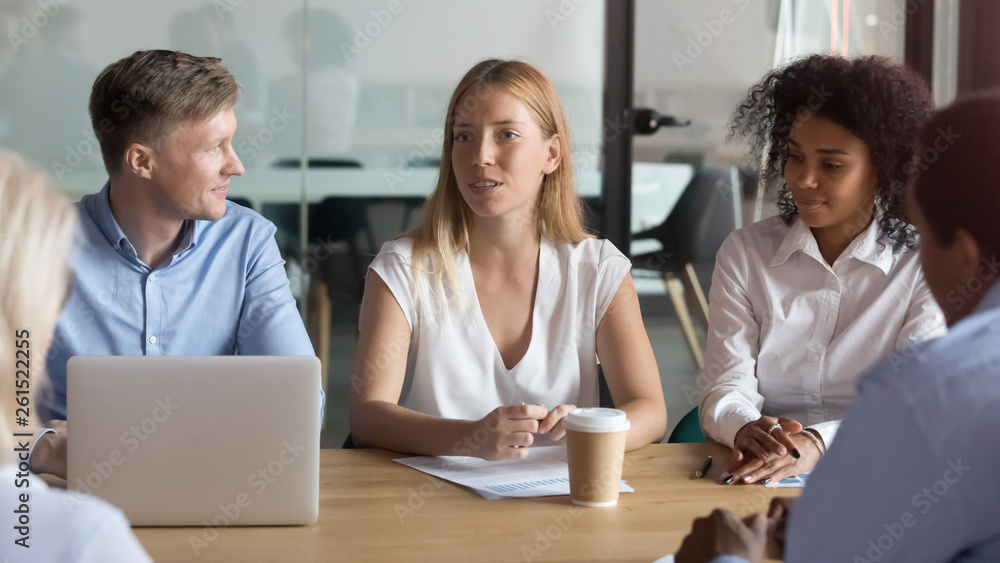 Confident female business leader negotiating with clients at group meeting Confident female business leader negotiating with clients at group meeting