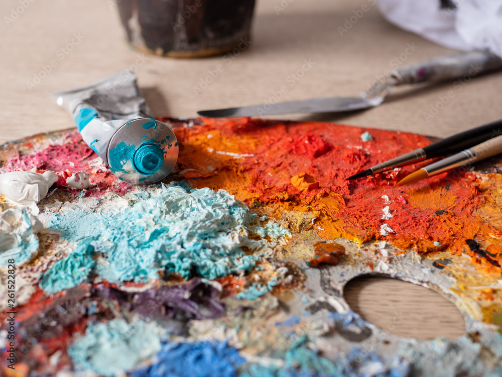 Artist's studio - closeup detail of a colourful palette with paint on Artist's studio - closeup detail of a colourful palette with paint on
