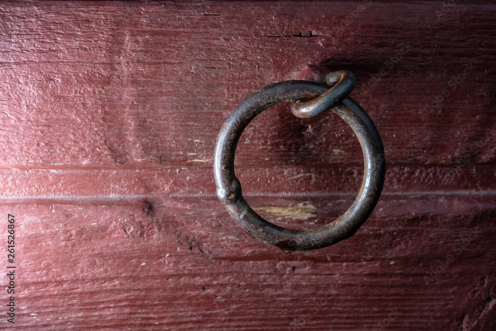 Welded metal link in red wooden wall Welded metal link in red wooden wall