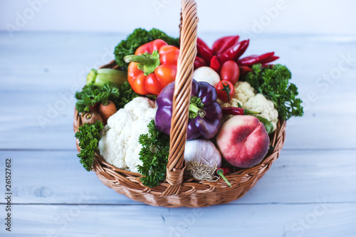 Basket of vegetables on a wooden table. Top view.