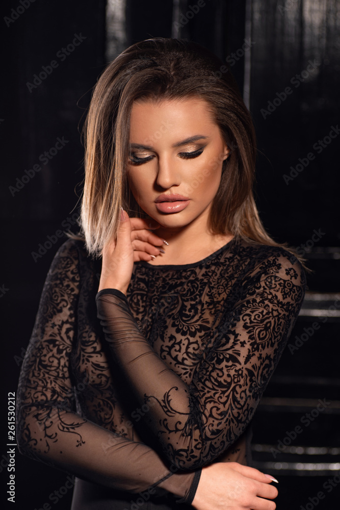 Young sexy girl posing in a lace bodysuit in a dark room Young sexy girl posing in a lace bodysuit in a dark room