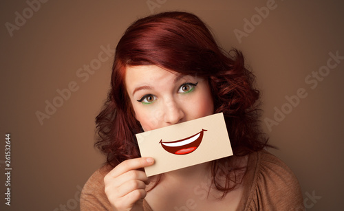 Person holding card in front of his mouth with ironic smile 