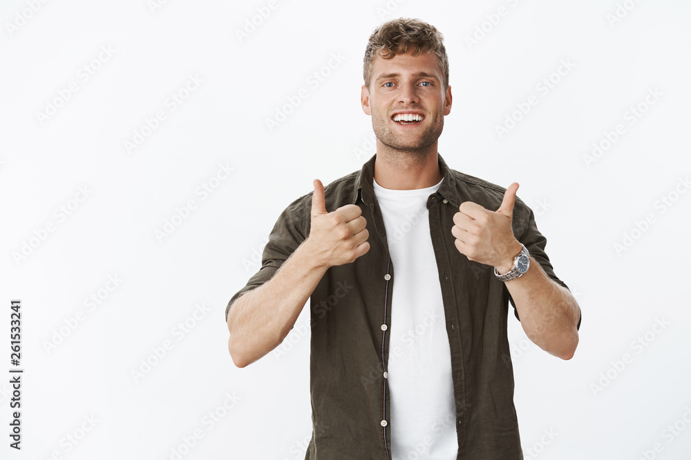 Nice work, you cool. Portrait of impressed and pleased male friend with charming smile showing thumbs-up in cheer and support, totally agree and satisfied with excellent choice over grey background Nice work, you cool. Portrait of impressed and pleased male friend with charming smile showing thumbs-up in cheer and support, totally agree and satisfied with excellent choice over grey background