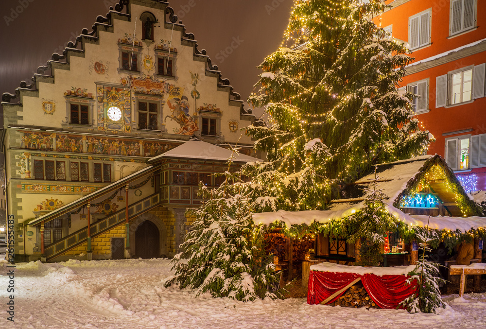 romantischer, idyllischer Winkel in der tief verschneiten Altstadt von Lindau mit schneebedecktem Christbaum, Weihnachtsbaum, altem Rathaus und Budenzauber