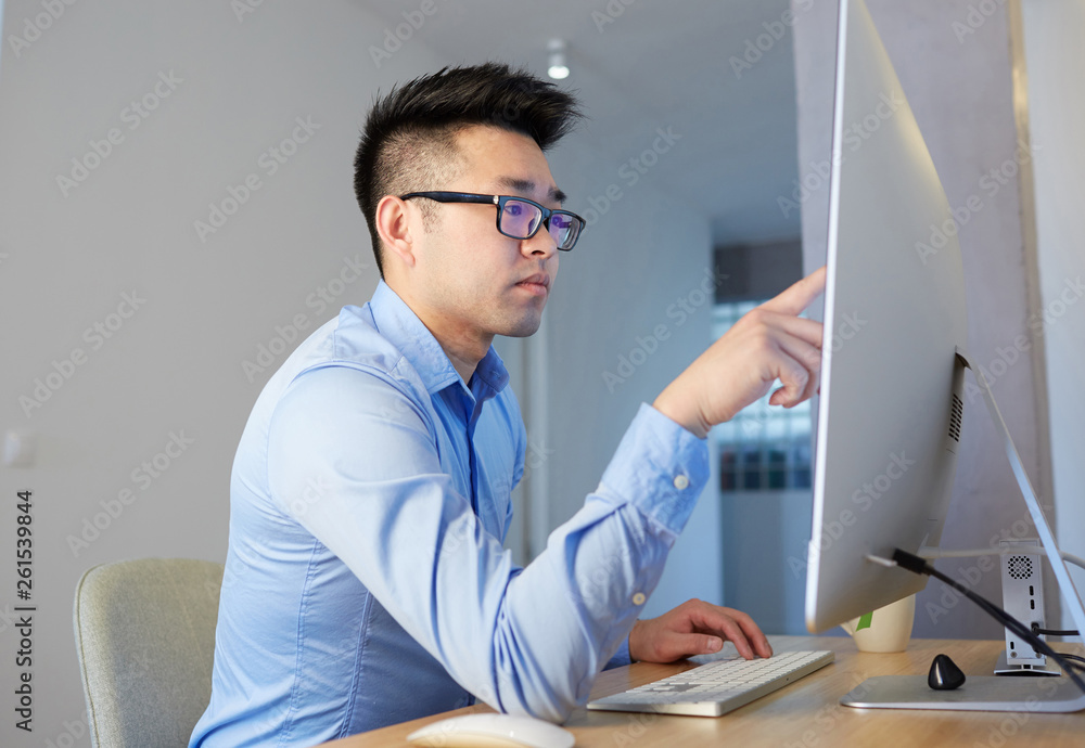 Young asian male programmer wearing shirt and glasses working while ...