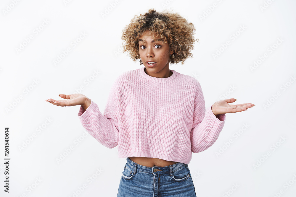 I have no suggestions. Portrait of clueless and confused cute unaware dark-skinned girl shrugging with hands spread sideways open mouth and lift eyebrows being doubtful and unaware over white wall I have no suggestions. Portrait of clueless and confused cute unaware dark-skinned girl shrugging with hands spread sideways open mouth and lift eyebrows being doubtful and unaware over white wall
