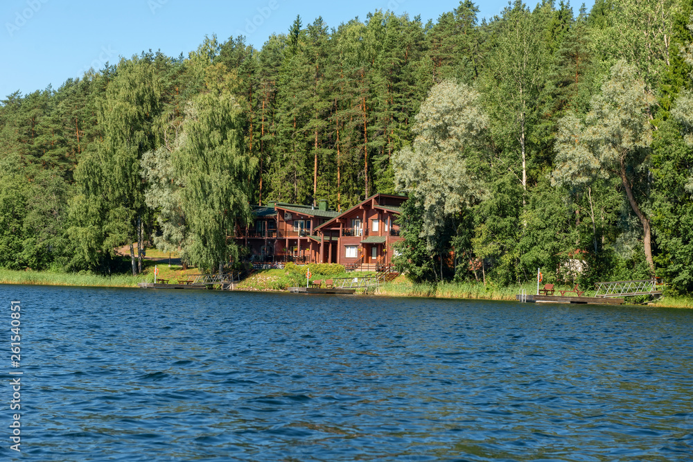 Obraz premium Building with a boat dock on the shore of a forest lake