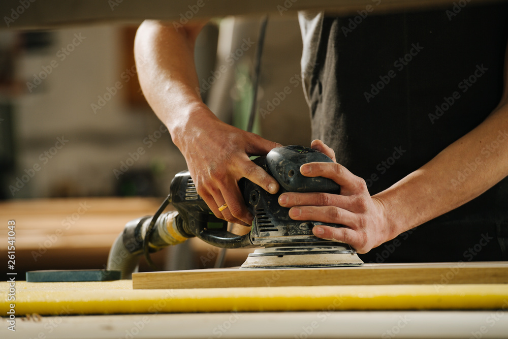 Carpenter is making furniture on order in a workshop. Carpenter is making furniture on order in a workshop.