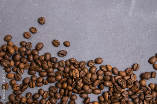 Roasted coffee beans in bulk on a gray concrete background. dark cofee roasted grain flavor aroma cafe, natural coffe shop background, top view from above, copy space