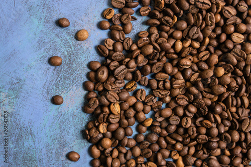 Roasted coffee beans in bulk on a blue background. dark cofee roasted grain flavor aroma cafe, natural coffe shop background, top view from above, copy space
