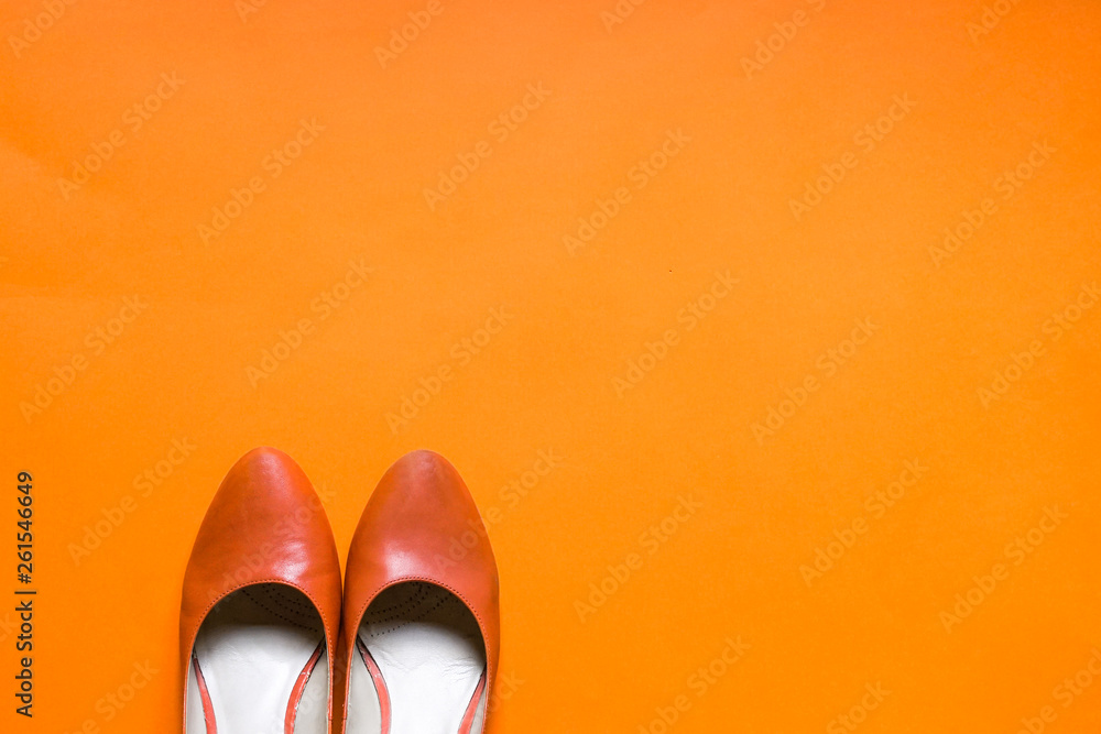 Funky orange high heels flat lay on orange background Funky orange high heels flat lay on orange background