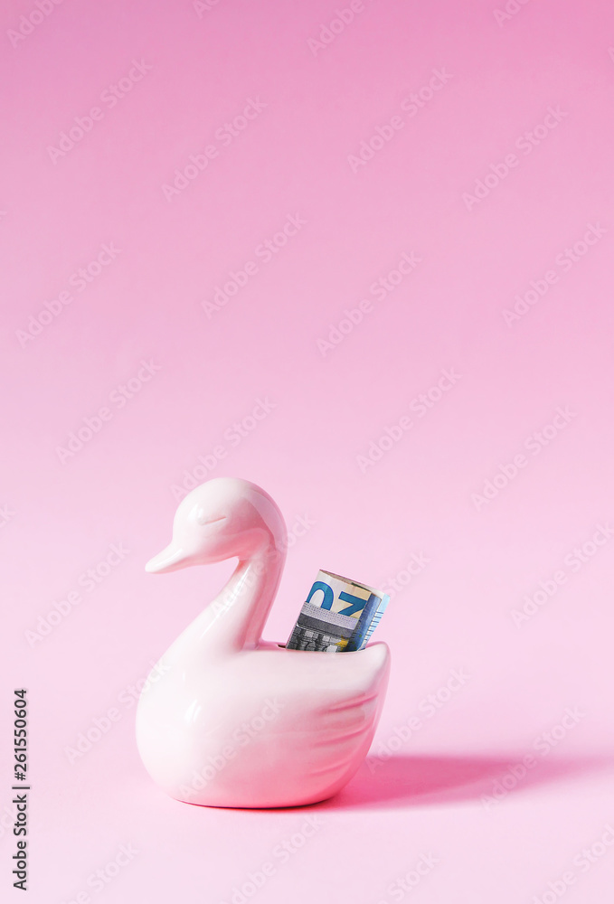 Funny duck piggy bank or money box with paper money on soft pastel background. Funny duck piggy bank or money box with paper money on soft pastel background.