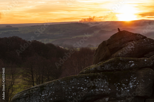 With smoke in the air the sun is setting over the Pennines near Pateley Bridge close to Brimham Rocks