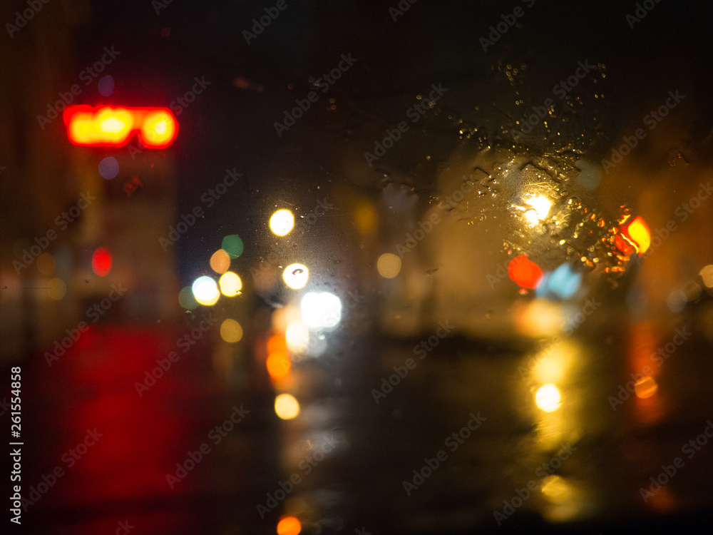 Night colored lights through wet glass.