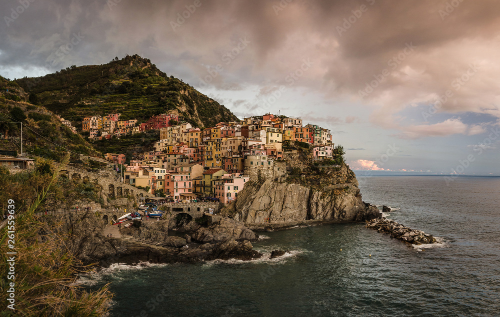 View of Manarola village and Ligurian sea from a hill at a cloudy sunset. Cinque Terre, Italy