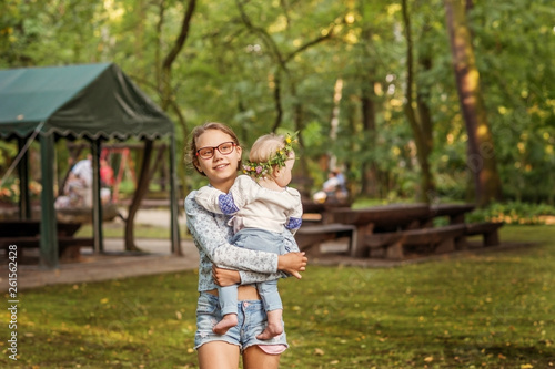 Teen girl with baby sister in the Park for a walk.