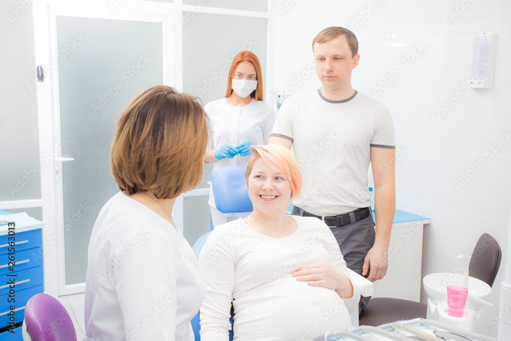 pregnant woman at the reception at the dentist, the husband  are present in the office. Dental treatment for pregnant women