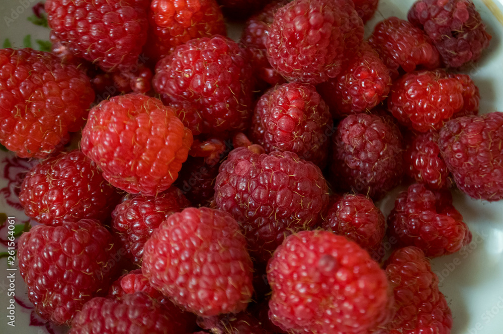 Big ripe raspberries are laying on the table covered with white tablecloth Big ripe raspberries are laying on the table covered with white tablecloth