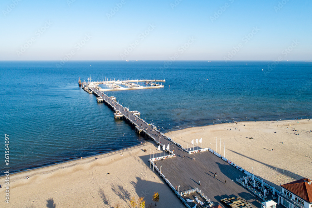 Wooden pier with harbor, marina with yachts and beach in Sopot resort near Gdansk in Poland in sunset light. Aerial view