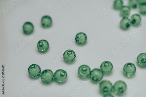 Green glass beads on a white background. Macro view. photo