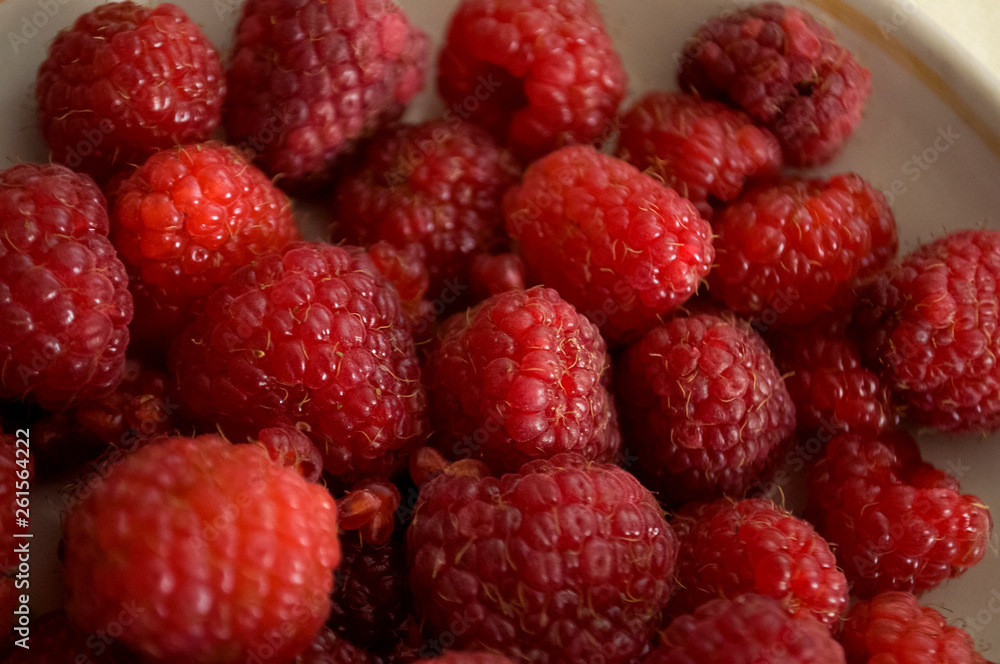 Big ripe raspberries are laying on the table covered with white tablecloth Big ripe raspberries are laying on the table covered with white tablecloth