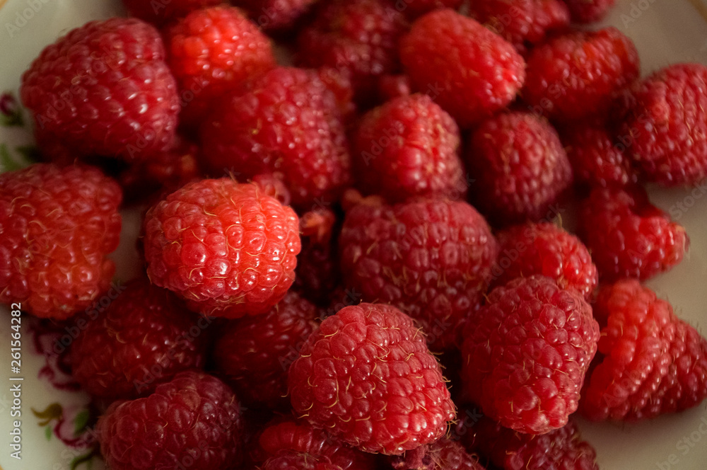 Big ripe raspberries are laying on the table covered with white tablecloth Big ripe raspberries are laying on the table covered with white tablecloth
