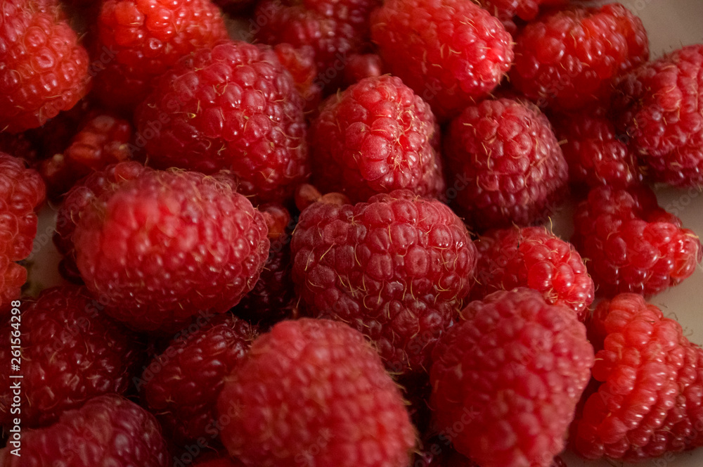 Big ripe raspberries are laying on the table covered with white tablecloth Big ripe raspberries are laying on the table covered with white tablecloth