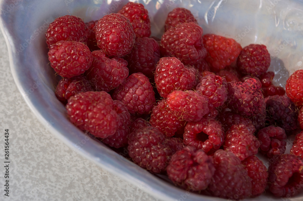 Big ripe raspberries are laying on the table covered with white tablecloth Big ripe raspberries are laying on the table covered with white tablecloth