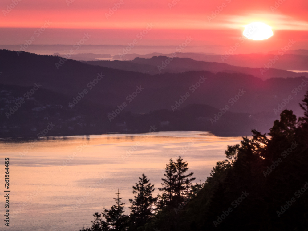 A beautiful and breathtaking view on fjords around Bergen, Norway, seen from the hill above the city. Endless fjords joining the sea. Sun sets over the horion. Beauty of the nature.