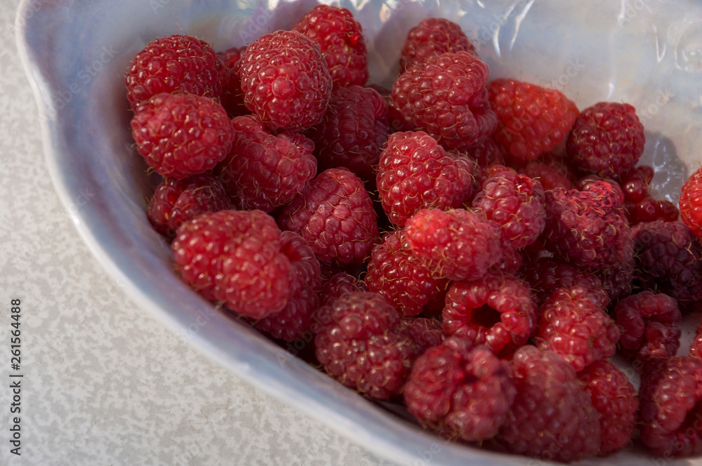 Big ripe raspberries are laying on the table covered with white tablecloth Big ripe raspberries are laying on the table covered with white tablecloth