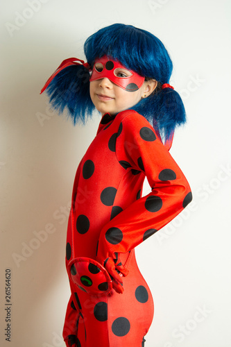 Corby, United Kingdom. March 12, 2019 - little girl in Ladybug Myraculous cosplay costume. Superhero ladybug with blue twig, isolated.