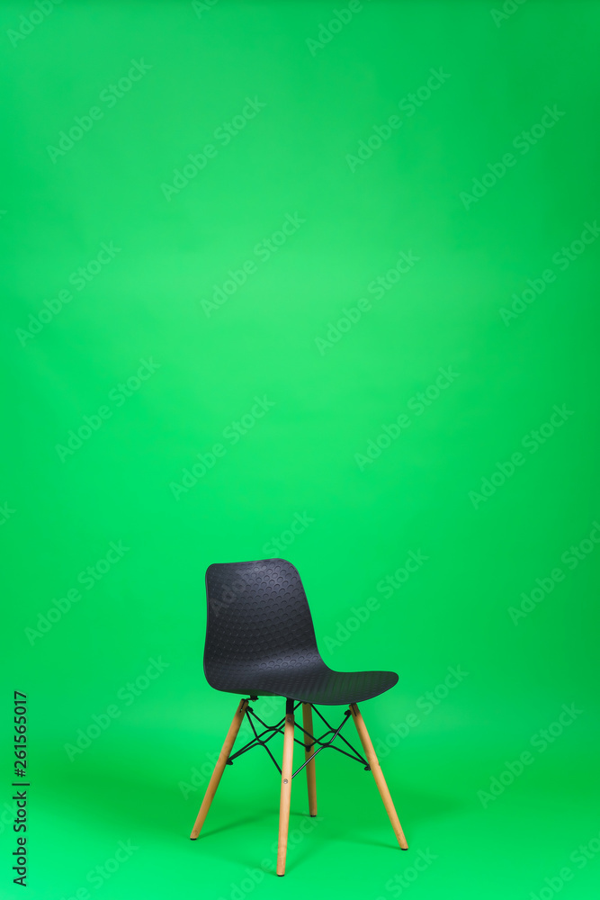 Black chair on a green background. Green chroma key in the studio. Studio  paper background. Designer chair with a plastic back and wooden legs. Stock  Photo | Adobe Stock