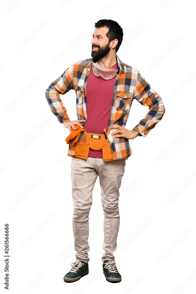 Craftsmen man posing with arms at hip and smiling over isolated white background Craftsmen man posing with arms at hip and smiling over isolated white background