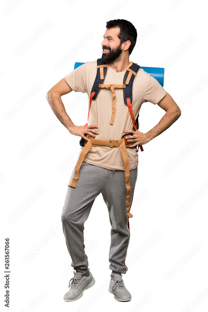Hiker man posing with arms at hip and smiling over isolated white background Hiker man posing with arms at hip and smiling over isolated white background