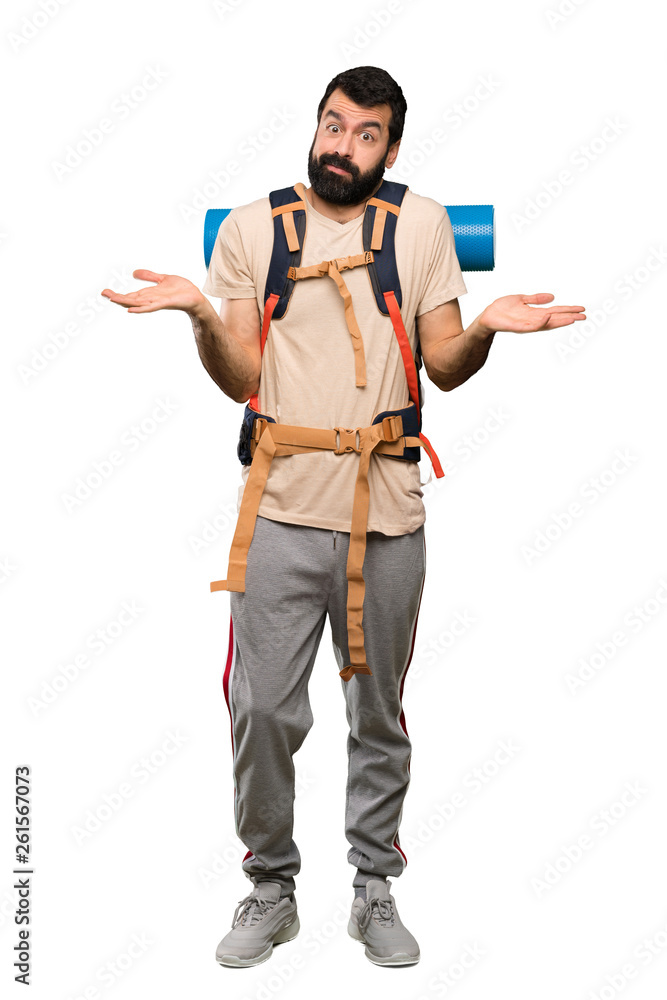 Hiker man having doubts while raising hands over isolated white background Hiker man having doubts while raising hands over isolated white background