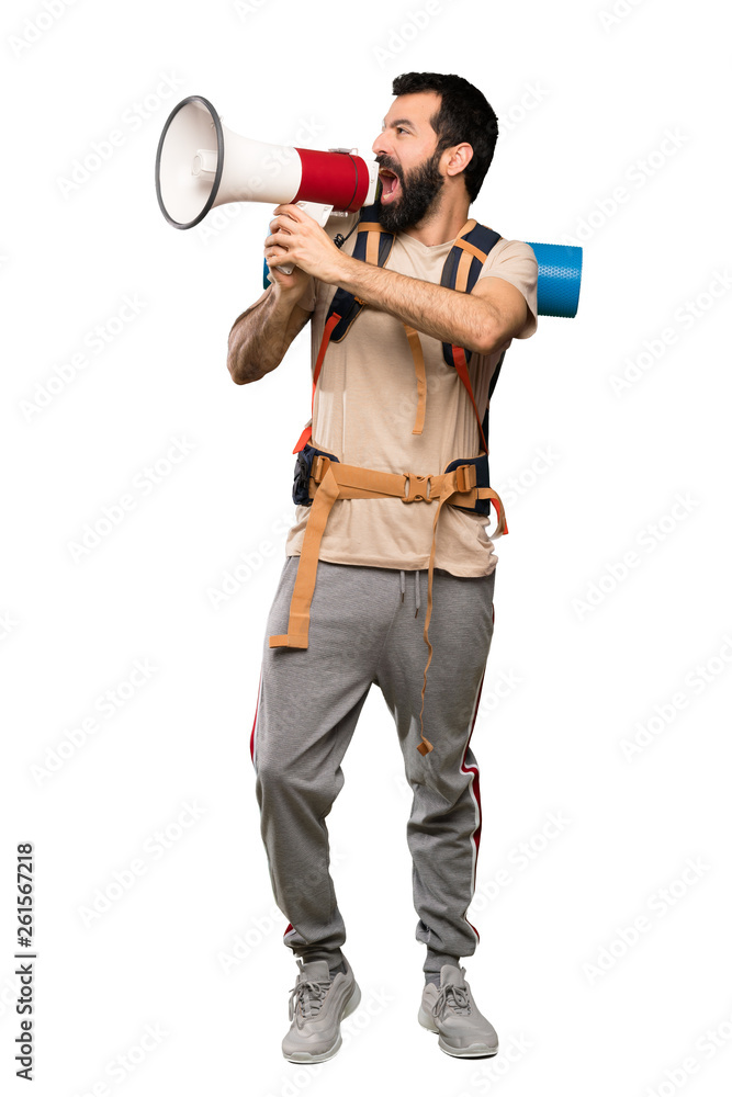 Hiker man shouting through a megaphone over isolated white background Hiker man shouting through a megaphone over isolated white background