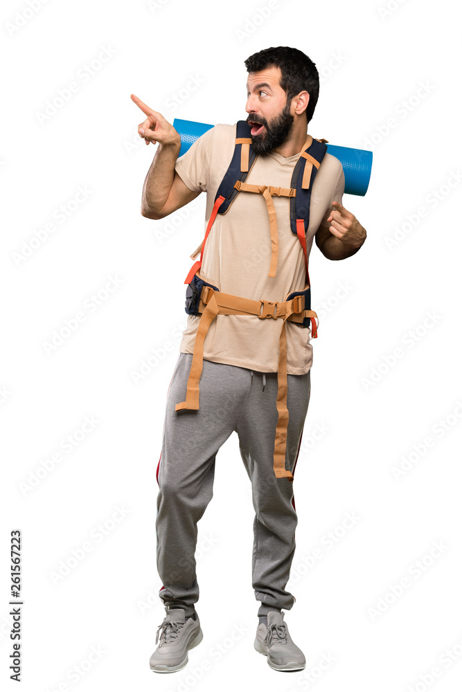 Hiker man pointing away over isolated white background Hiker man pointing away over isolated white background